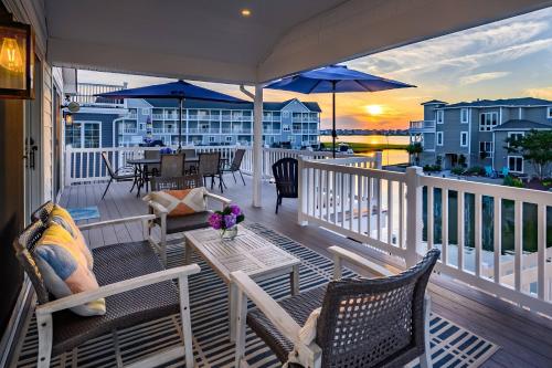 a porch with chairs and a table and umbrella at 47 Oyster Bay Dr, Fenwick Island in Fenwick Island