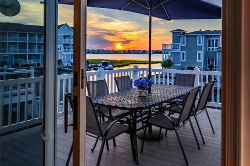 a table with chairs and an umbrella on a balcony at 47 Oyster Bay Dr, Fenwick Island in Fenwick Island