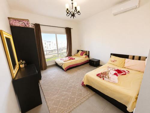 a bedroom with two beds and a window at AMWAj in El Alamein