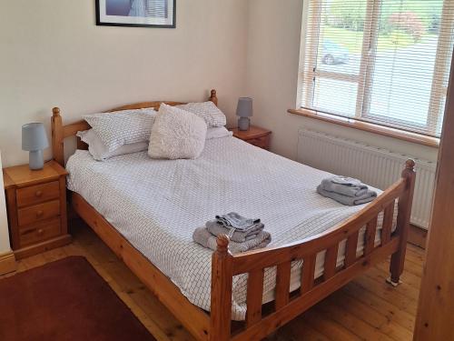 a bedroom with a wooden bed with towels on it at 19 River Glen in Curracloe