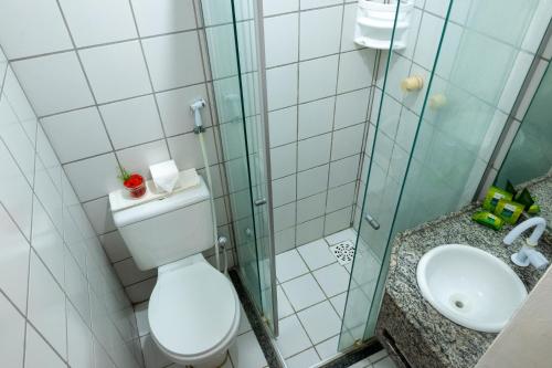 a bathroom with a shower and a toilet and a sink at Samba Pousada in Jericoacoara