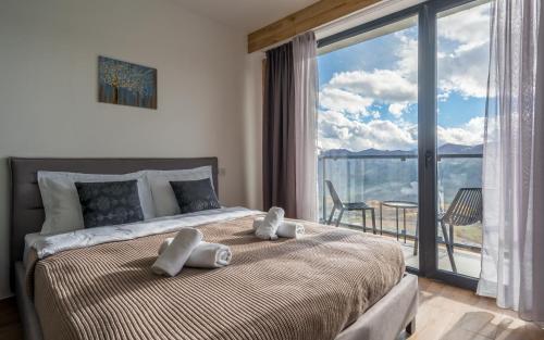 a bedroom with a large bed with a large window at New Gudauri Twins Horizon in Gudauri