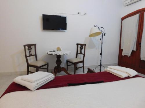 a bedroom with a bed with two chairs and a table at Hotel Portal del Santo in Cafayate