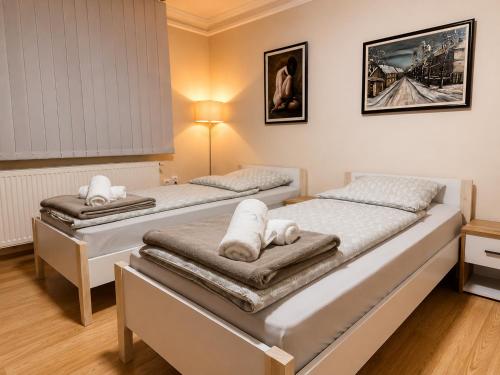 two beds in a room with towels on them at Royal Apartmani in Negotin