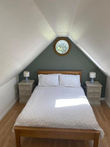 a bedroom with a bed with two night stands and a window at The Burren Snug in Galway