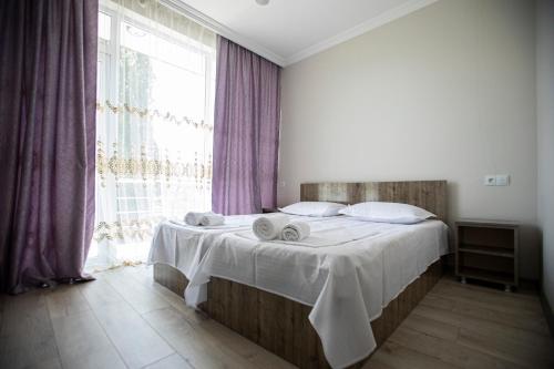 a bedroom with a bed with towels on it at Guest House on Rustaveli 176 in Kobuleti