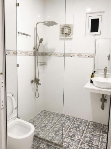 a bathroom with a shower and a toilet and a sink at Bungalow Gió Hát in Phú Quốc