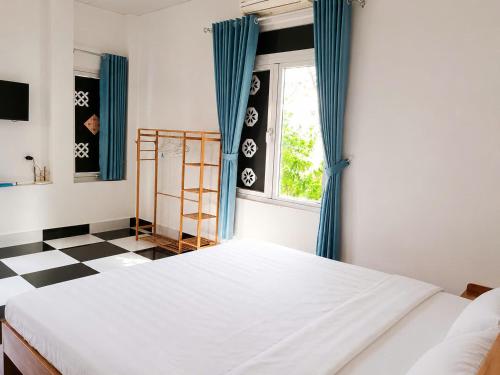 a bedroom with a bed and a checkered floor at Bungalow Gió Hát in Phú Quốc