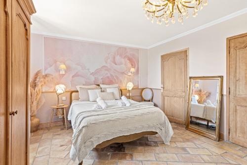 a bedroom with a large bed and a chandelier at Maison Casasand Maison d'hôtes de charme in Grasse