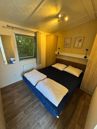 a bedroom with a bed in a small room at Beach Chalet Sunny Dunes in Petten
