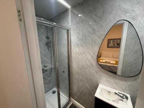 a bathroom with a shower and a mirror at The President Hotel in Blackpool