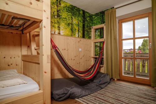 a hammock in a room with a tree mural at Dienberger Ferienhaus in Untergriesbach