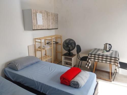 a bedroom with a bed and a desk with a fan at Quarto superior Privativo in Itupeva
