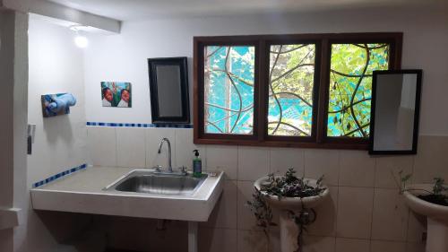 a bathroom with a sink and a stained glass window at Garden Rooms in Bocas Town