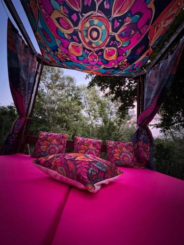 a bed in a gazebo with a pink ceiling at Къща за гости Дени in Chukovezer