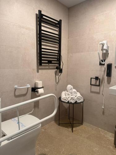 a bathroom with a toilet and a table with towels at STAR BAY Hotel in Calafell