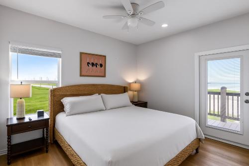 a white bedroom with a bed and a window at Spacious Beachfront 5BR with Gorgeous Ocean views - Blue Footed in Bolivar Peninsula