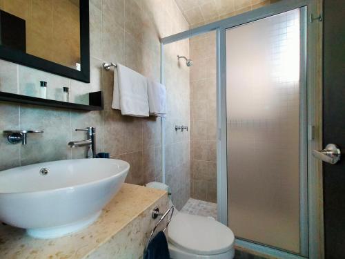 a bathroom with a white sink and a shower at CasaMEXH Lunamar - Despierta, toma café en la 5ta Av, explora Xcaret, experimenta Tulum o algún cenote cercano - Unas vacaciones extraordinarias para tu familia y tus amigos in Playa del Carmen