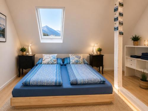 a bedroom with two beds with blue sheets and a window at Ferienwohnung Attersee in Steinbach am Attersee