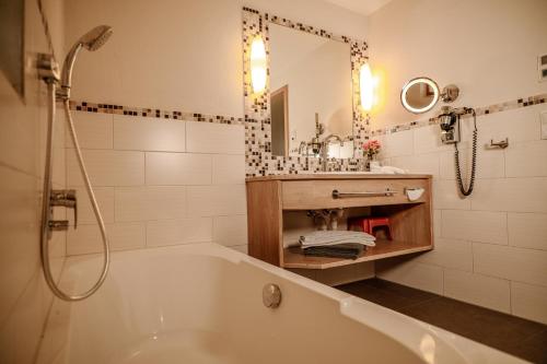 a bathroom with a tub and a sink and a mirror at Dienberger Ferienhaus in Untergriesbach