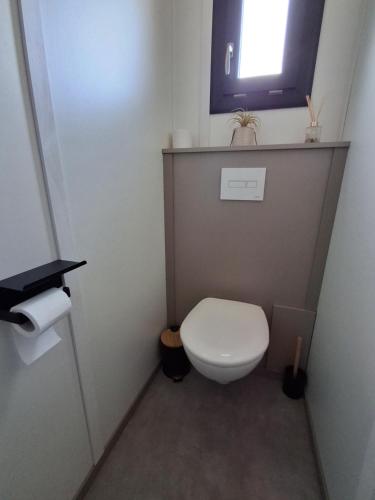 a small bathroom with a toilet and a window at Chalet in Gouesnach