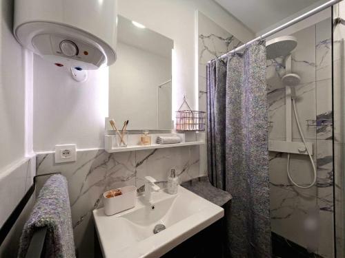 a white bathroom with a sink and a shower at Apartman"Petra" in Krk