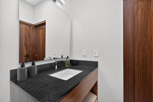 a bathroom with a black counter and a sink at Unit Aguacates Romantic Zone in Puerto Vallarta