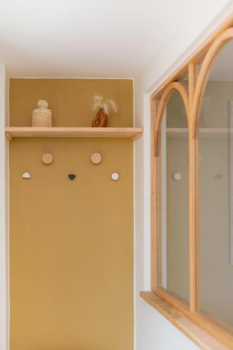 a room with a shelf and a mirror at Villa Raphia - Maison d'hôtes in Hardelot-Plage