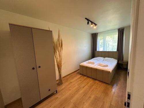 a bedroom with a bed and a large window at Apartament Grodzka in Wałbrzych