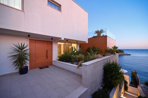 a house with a balcony with a view of the ocean at Aparatment house Gloss Primosten in Primošten