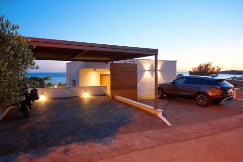 a car parked in front of a house with a garage at Aparatment house Gloss Primosten in Primošten