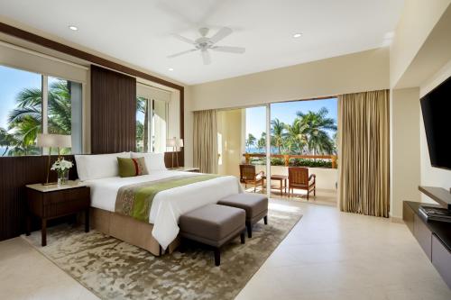 a bedroom with a large bed and a balcony at Grand Velas Riviera Nayarit-All Inclusive in Nuevo Vallarta