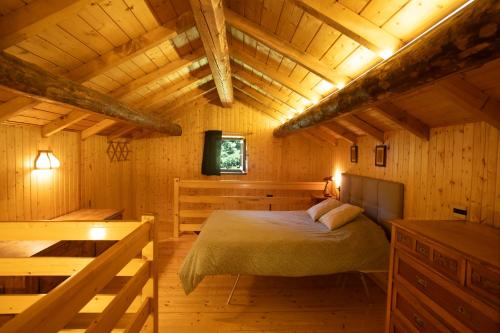 a bedroom in a wooden cabin with a bed at Casera Marisa Nevegal in Nevegal