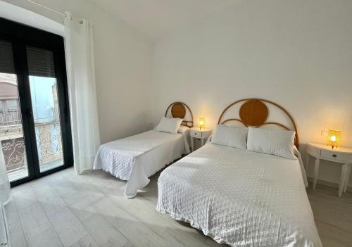 a bedroom with two beds and two tables and a window at Señorón & Requesón in Olivenza