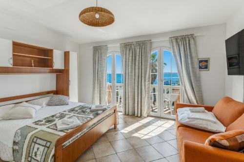 a bedroom with a bed and a couch at Utković Beachfront Apartments in Vrsi