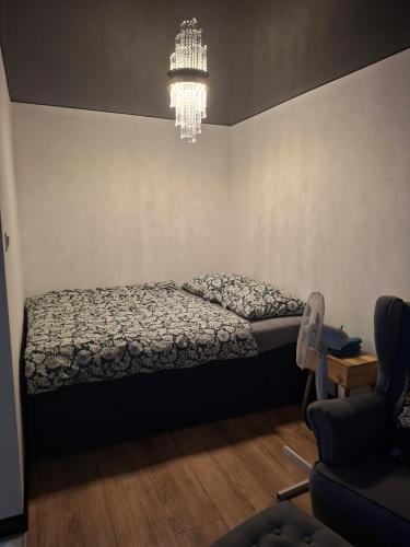 a bedroom with a bed and a chandelier at Łokietka in Inowrocław