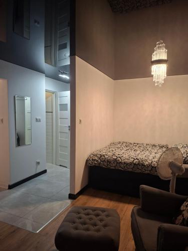 a bedroom with a bed and a chandelier at Łokietka in Inowrocław