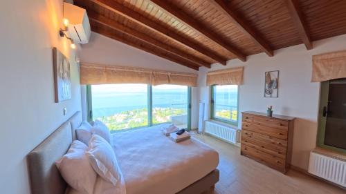 a bedroom with a large bed with a large window at Theologos Ridge in Theologos