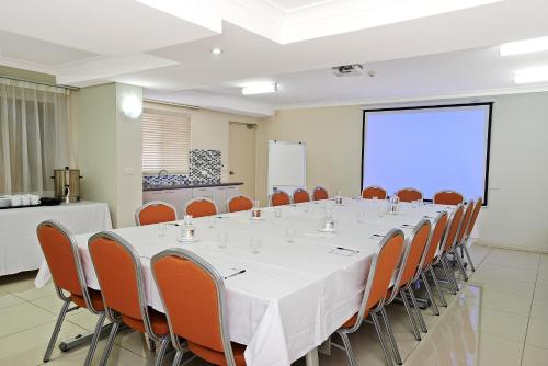 a conference room with a long table and chairs at Comfort Inn & Suites Burwood in Sydney