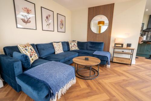 a living room with a blue couch and a table at The Nook in Claypits