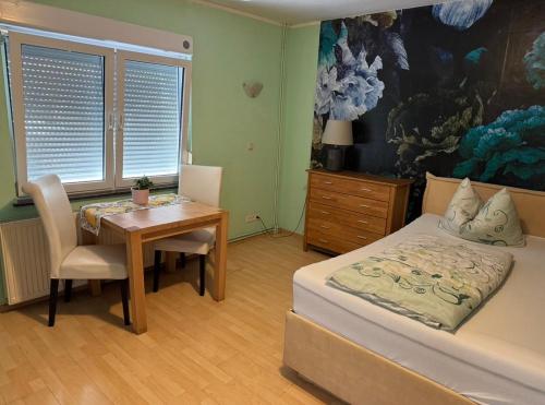 a bedroom with a bed and a desk and a table at Bauernhof Privatzimmer Frei WiFi Gemeinschaftsbad in Hausbreitenbach