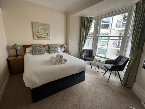 a bedroom with a bed and a large window at Myrtle House Hotel in Tenby