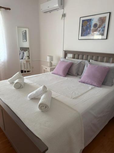 a bedroom with a large white bed with towels on it at M & A Ionian Balcony in Himare