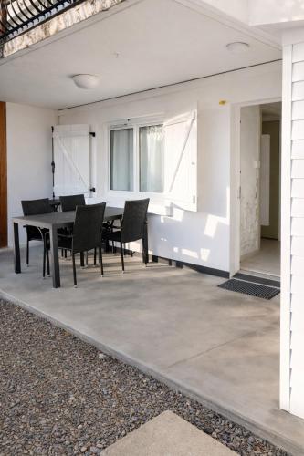 a dining room with a table and chairs on a patio at Appartement Coloquinte-Résidence Les Glycines in Eugénie-les-Bains