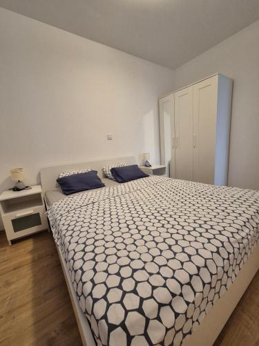a bedroom with a large bed with blue pillows at Kuća za odmor Postonjski in Maslenica