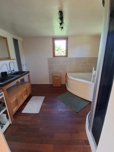 a bathroom with a bath tub and a sink at Chez les Wawas in Sainte-Agathe-dʼAliermont