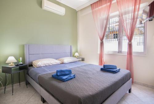 a bedroom with a bed with two blue towels on it at Ξενώνας της Αγάπης in Salamina