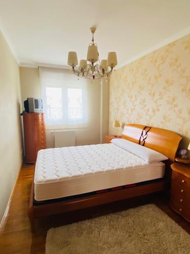 a bedroom with a large bed and a chandelier at NEXT STOP PLAYA SALINAS in Salinas