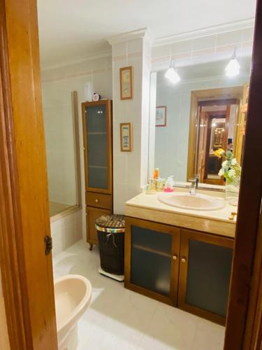 a bathroom with a sink and a toilet and a mirror at NEXT STOP PLAYA SALINAS in Salinas