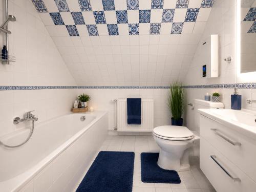 a bathroom with a toilet and a tub and a sink at Ferienwohnung Attersee in Steinbach am Attersee